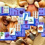 Brikker med strand- og sommermotiver placeret over en baggrund af sand og muslingeskaller