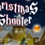 Tekst Christmas Shooter i gotisk skrift med glitrende dekorationer og farvede kugler på en vinter baggrund med sneklædte huse