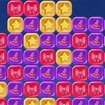 Farverige blokke i rødt, gult og lilla med symboler som stjerner, hatte og sløjfer arrangeret i rækker på en blå baggrund