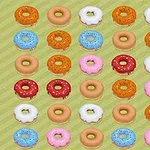Farverige donut-mønstre arrangeret i rækker på en grøn baggrund
