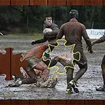 Flere mænd spiller rugby på en mudret bane med et puslespilsstykke indsat i midten