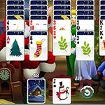 En række kort med julemotiver vist foran to personer og en pejs i en festligt dekoreret stue