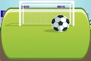 En fodbold og et mål på en grøn fodboldbane med bygninger i baggrunden