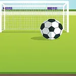 En fodbold og et mål på en grøn fodboldbane med bygninger i baggrunden