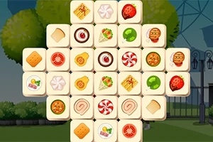 Et puslespil består af kvadratiske brikker med forskellige madillustrationer som småkager, pizza, og slik, arrangeret i et krydsmønster mod en udendørs baggrund